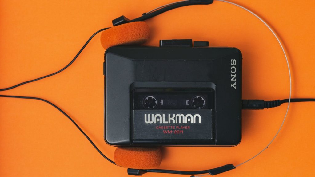 An old Sony walkman with a music cassette in it.